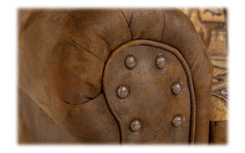 Close-up of a tufted, nailhead decorated leather armrest.