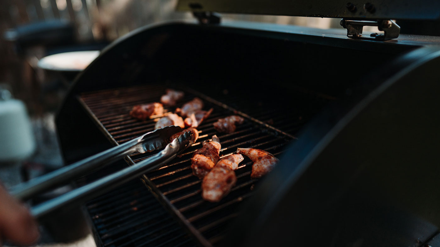 Rabbit meat being cooked on a grill.