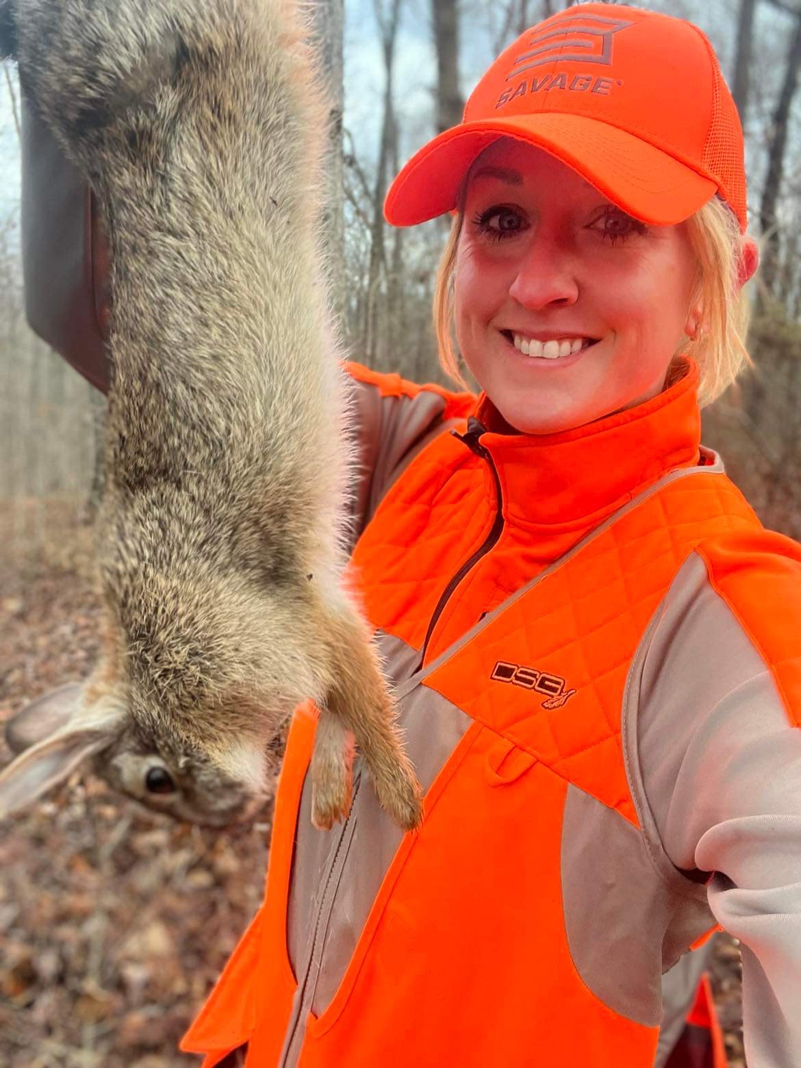 Hunter holding up a rabbit she got while hunting.