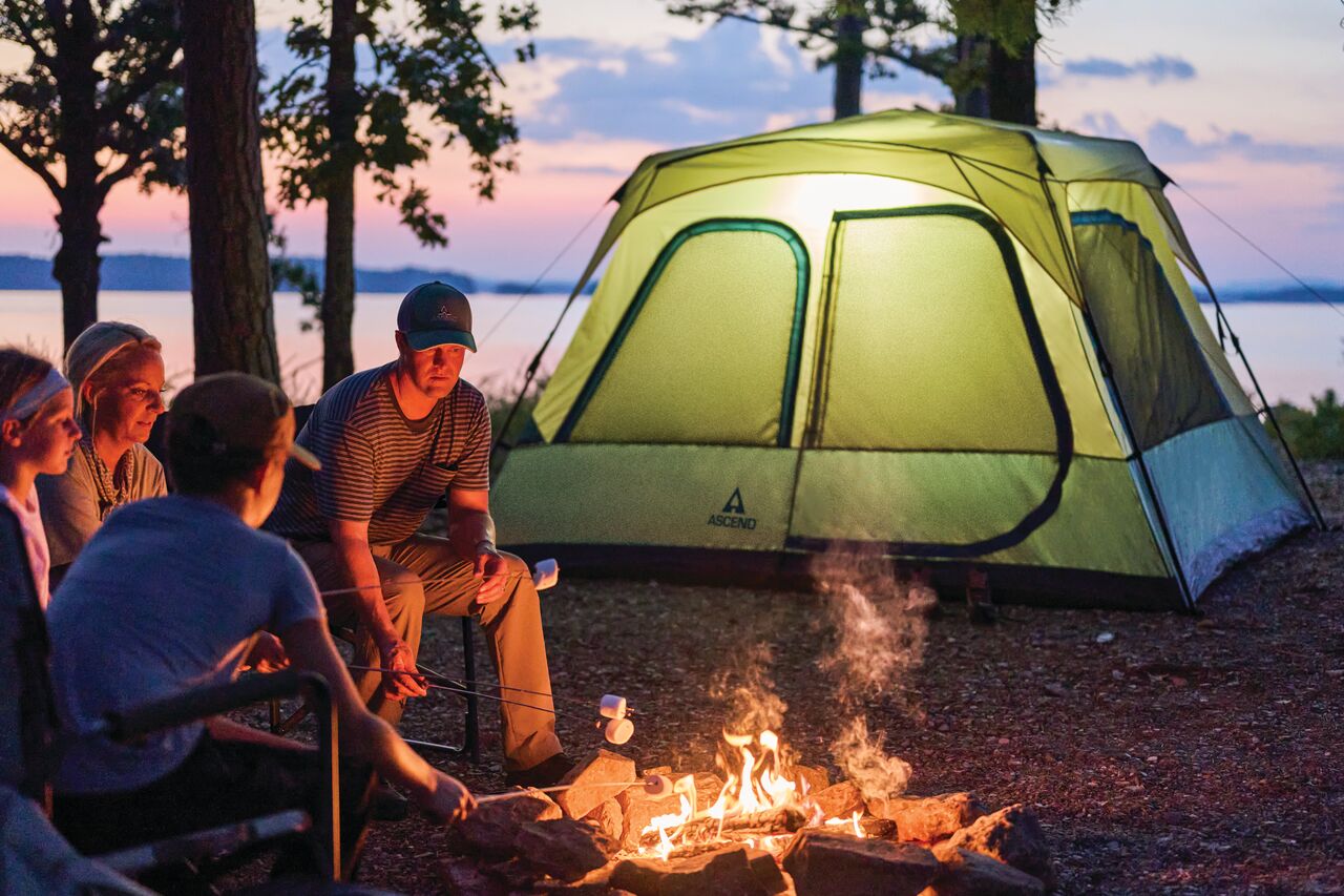 Family enjoying time next to an Ascend Lighted Instant Cabin Tent at a campsite.
