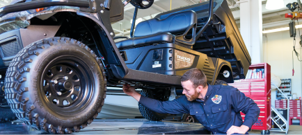 A technician services an ATV.