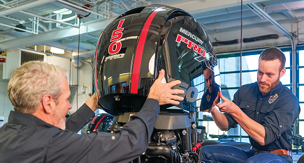 Two men service a boat's engine.