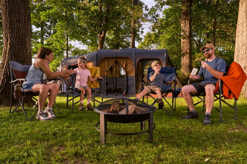 Family enjoying Nature’s Wonders snacks during a camping trip beside a lake