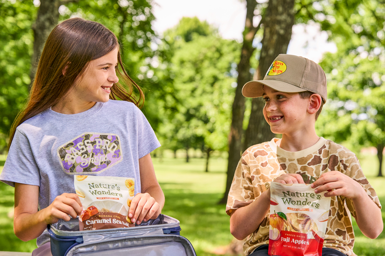 Family sharing snacks at a campsite beside a lake